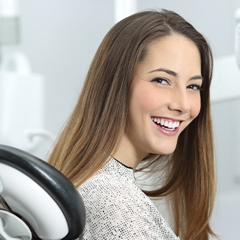 Woman in dental chair laughing