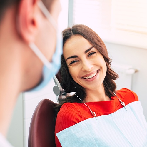 Woman in dental chair smiling at dentist