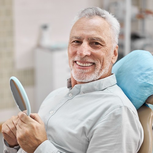 Older man in dental chair smiling
