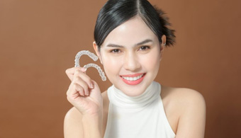 Lady smiles showing off Invisalign clear aligners