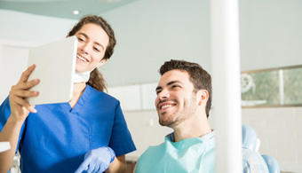 Dentist explains something to smiling patient