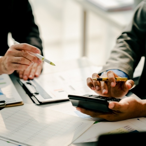 Professional CPA reviewing documents with a client in a modern office