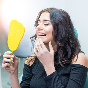 Woman looking at smile after cosmetic dentistry