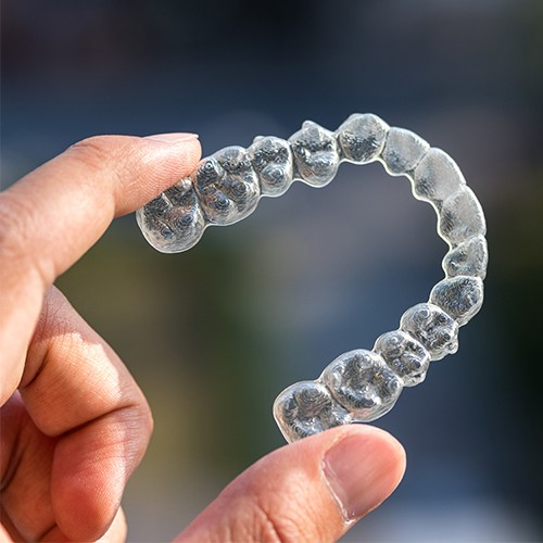 Hand holding Invisalign clear braces
