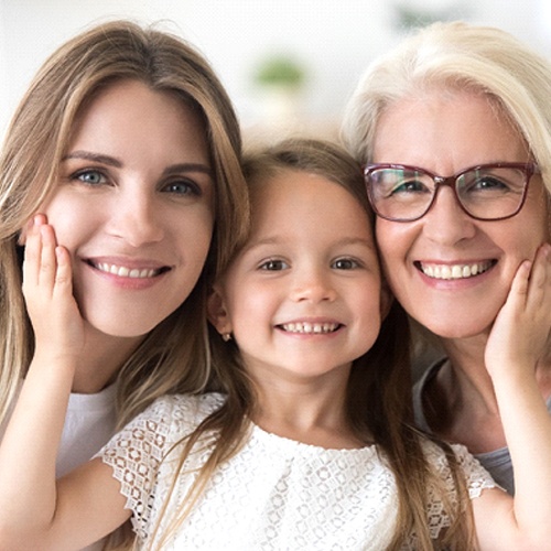 A mother and daughter posing with the grandmother who feels more confident thanks to her dentures in Jacksonville