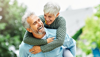 a mature couple with dentures smiling and laughing