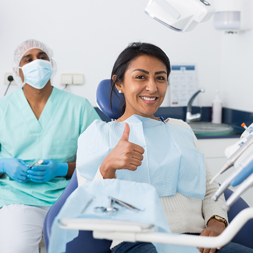 Woman giving thumbs up after emergency dental care in Jacksonville