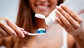 Woman with dental implants in Jacksonville, FL about to brush teeth