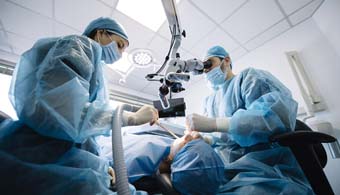 a dentist and dental assistant placing dental implants in a patient’s mouth