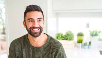 smiling person wearing a green sweater