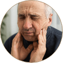 man holding his mouth in pain