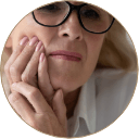 woman holding her mouth in pain