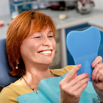 Woman looking at her smile in the mirror