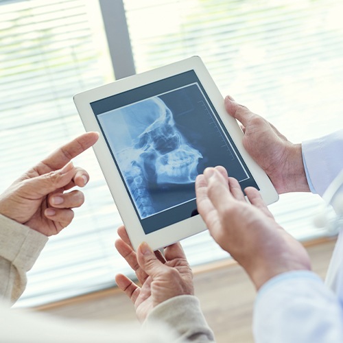 Dentists examining x-rays of jaw and skull for T M J diagnosis and treatment planning