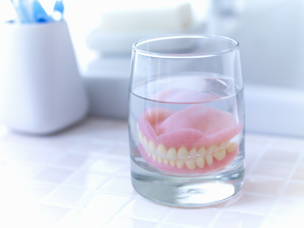dentures soaking in cup of water
