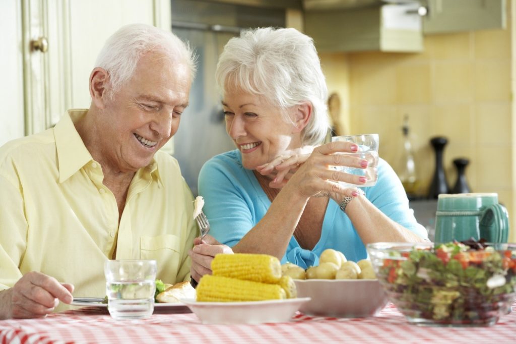 Couple eating summer foods with dental implants.