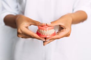 Closeup of a person holding their dentures.