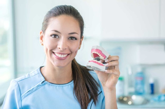 dentist holding out pair of dentures