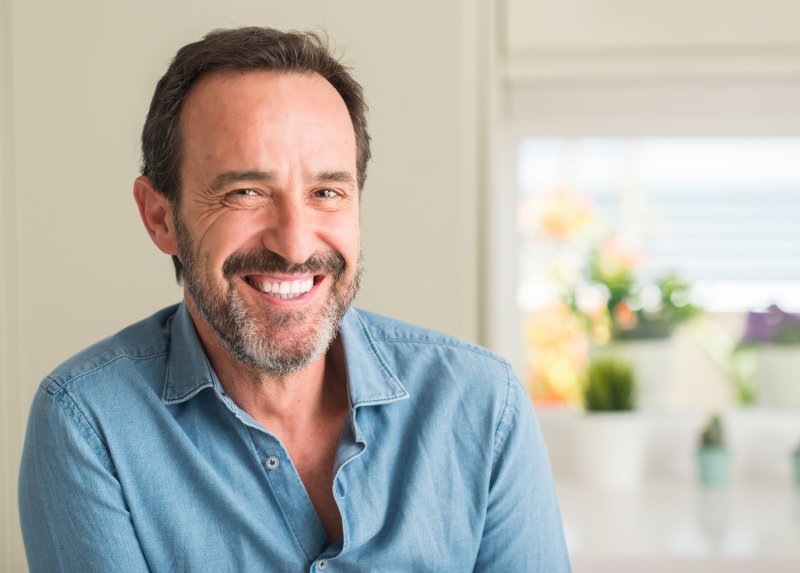 An older man smiling with his new dentures