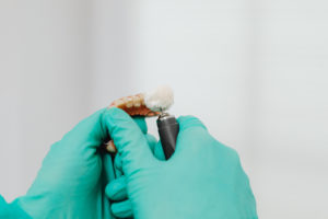 Close up of hands polishing a denture