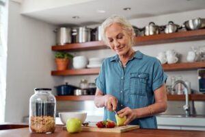Woman with dental implants cutting fruit