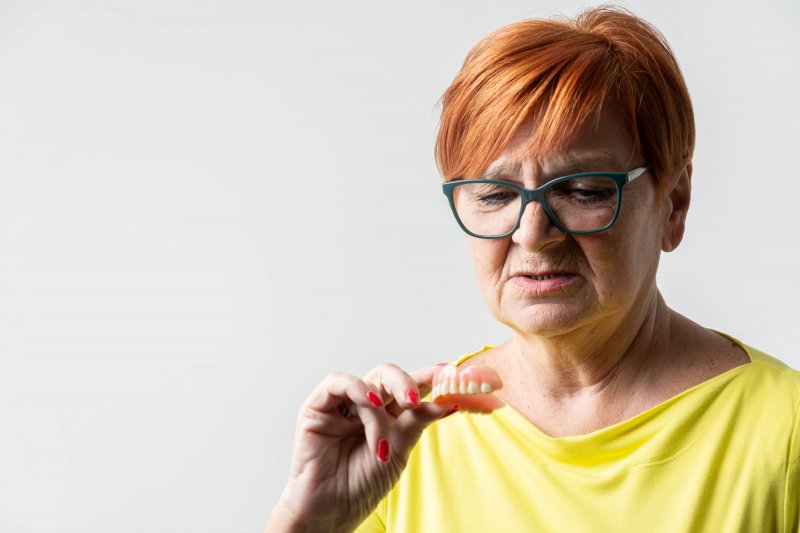 Older woman casting doubt on her dentures
