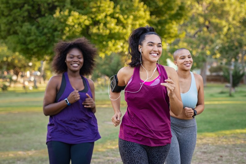 Patient smiling while jogging with friends